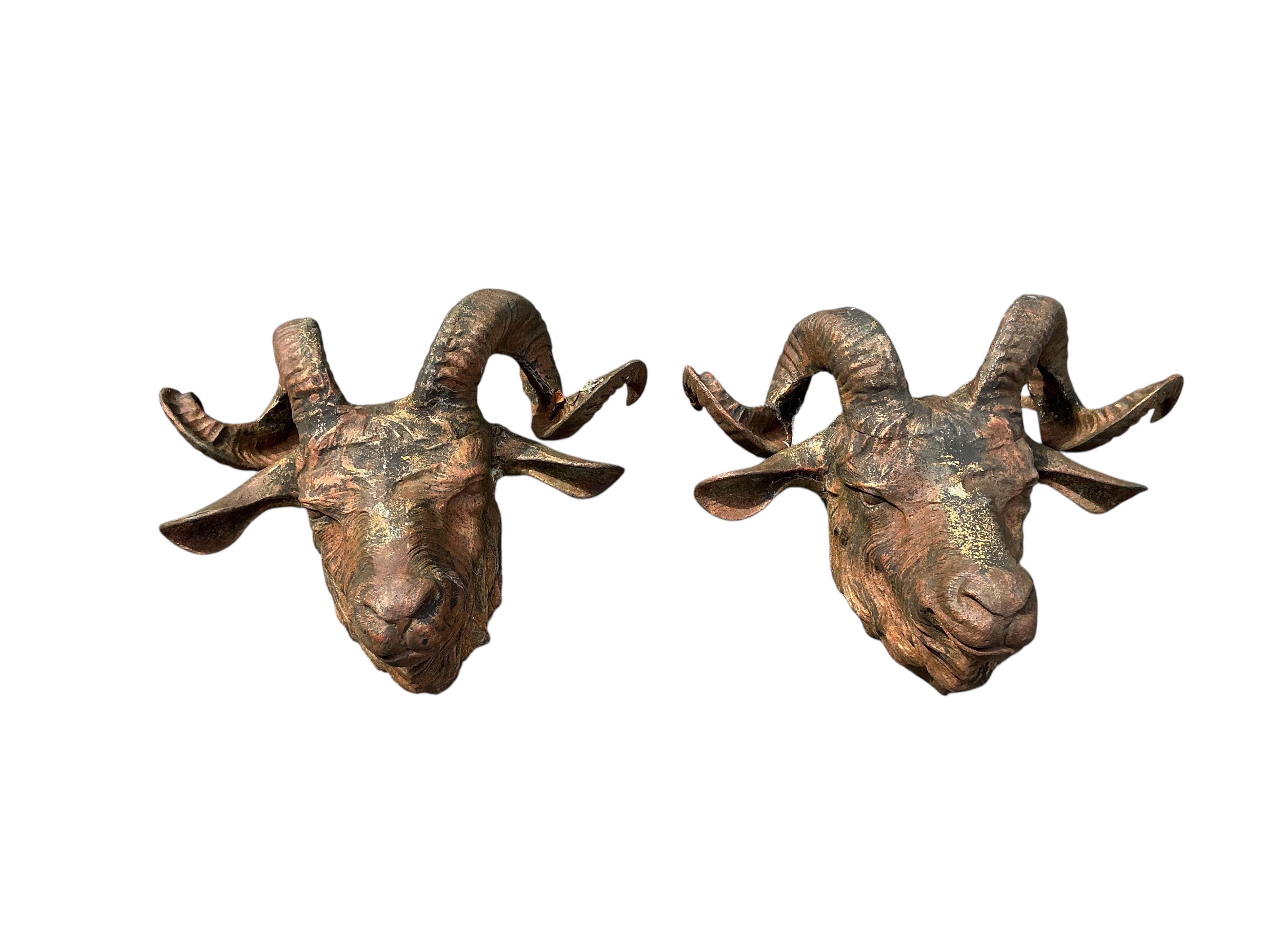 A set of four cast iron ram's head garden wall appliqués, width 48cm, height 36cm